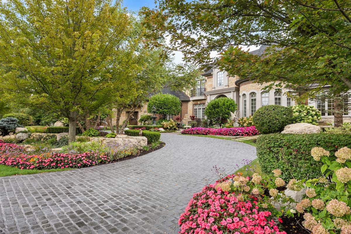 Lush landscaped garden and paver drive in full bloom